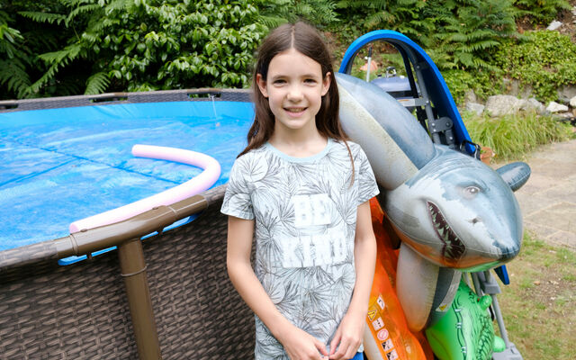 A child in front of a paddling pool