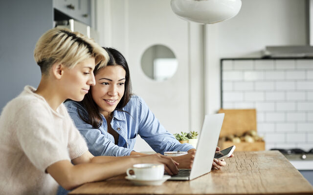 two people looking at a laptop