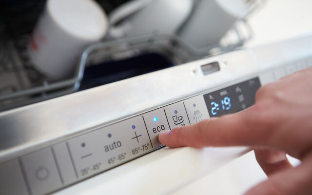 Pressing the eco button on a dishwasher